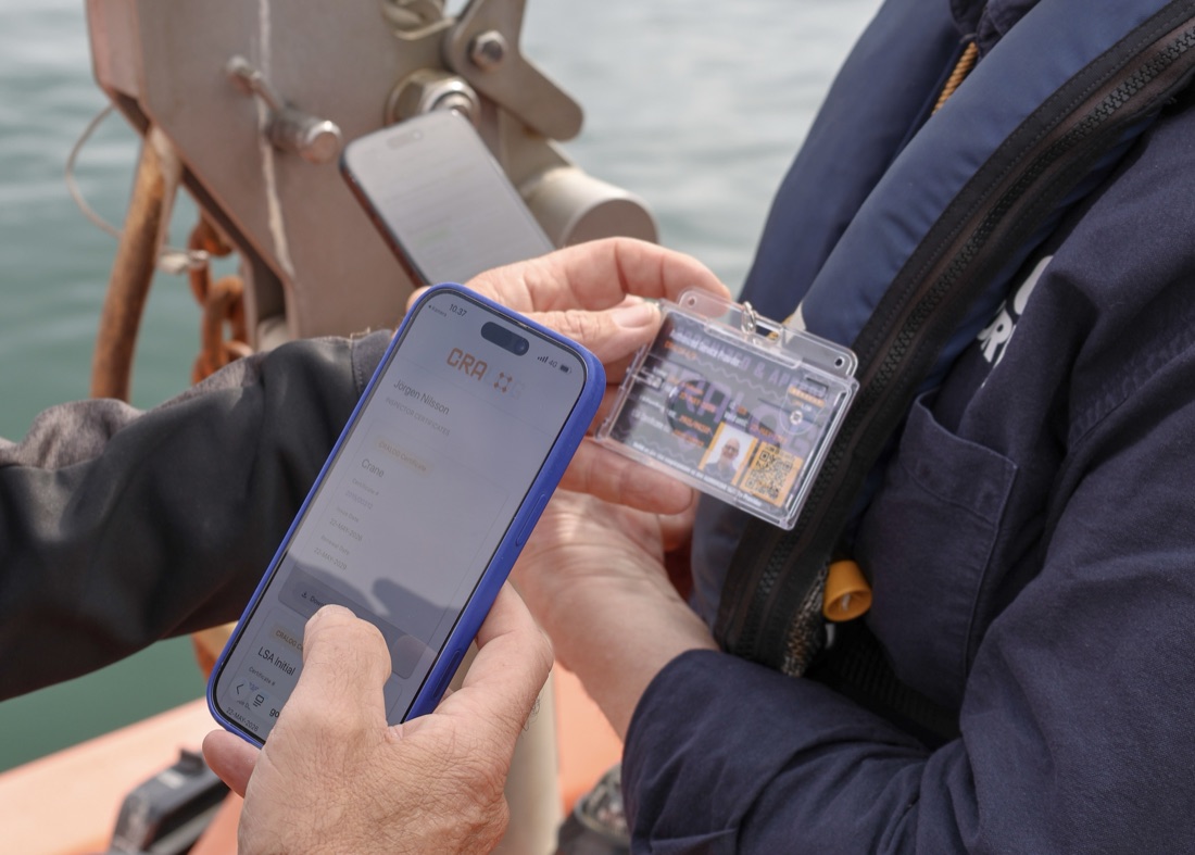 An inspector verifying a colleague's CRALOG ID card by scanning its QR code on the CRALOG app